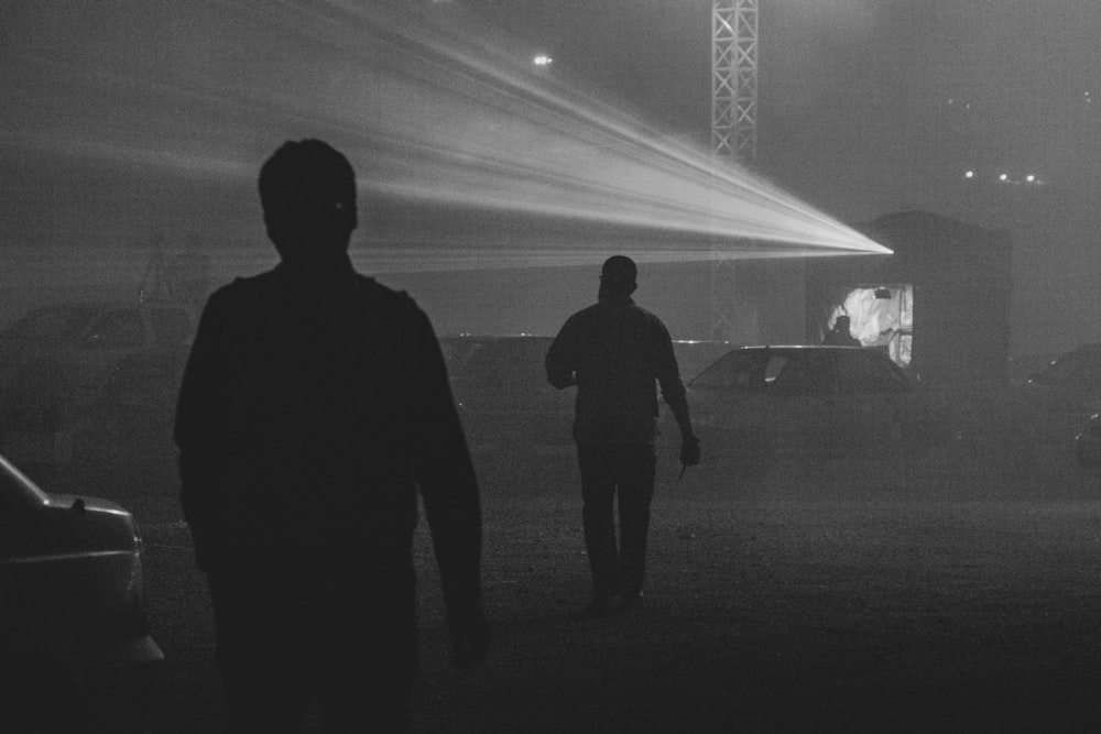 silhouette of 2 men standing on field