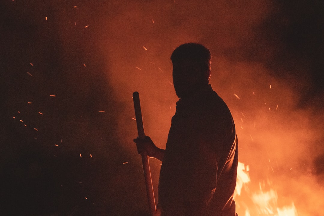 silhouette of man holding stick