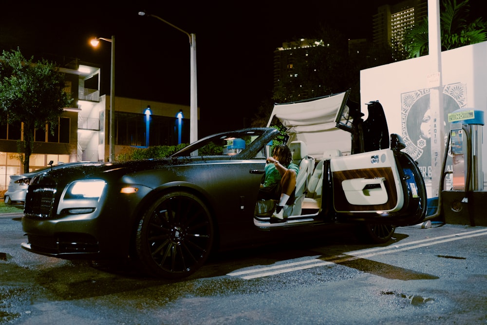 black car parked in front of white building during night time