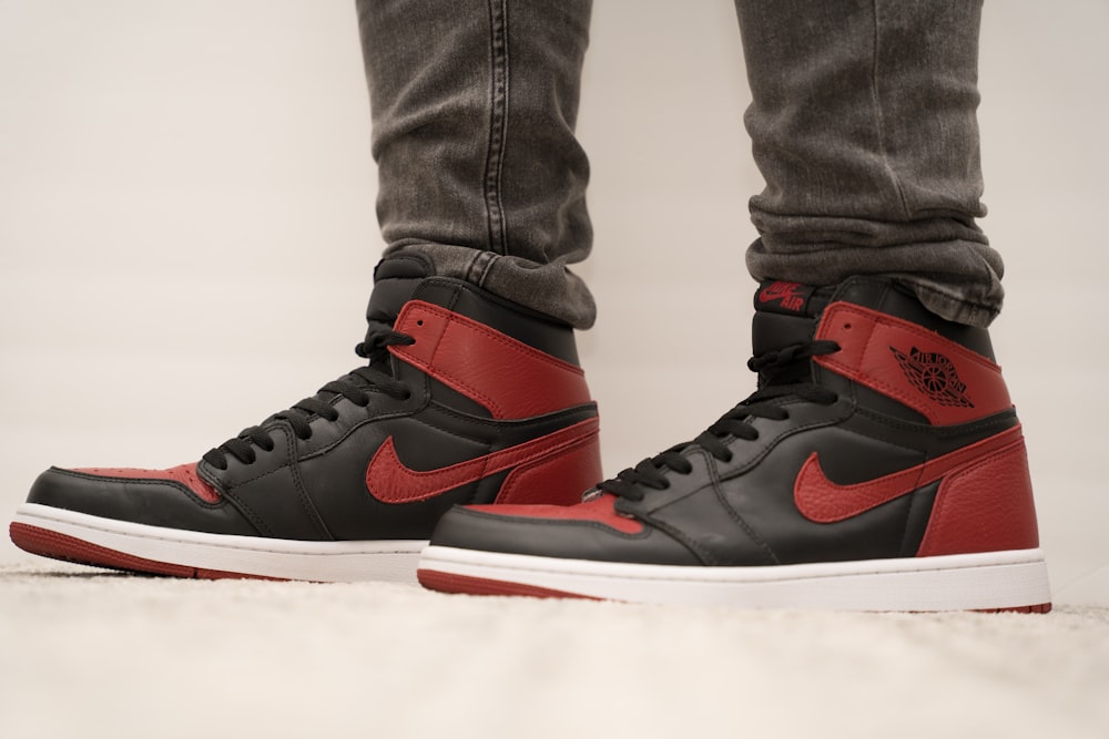 person wearing black red and white nike air jordan 1 shoes photo – Free Usa  Image on Unsplash