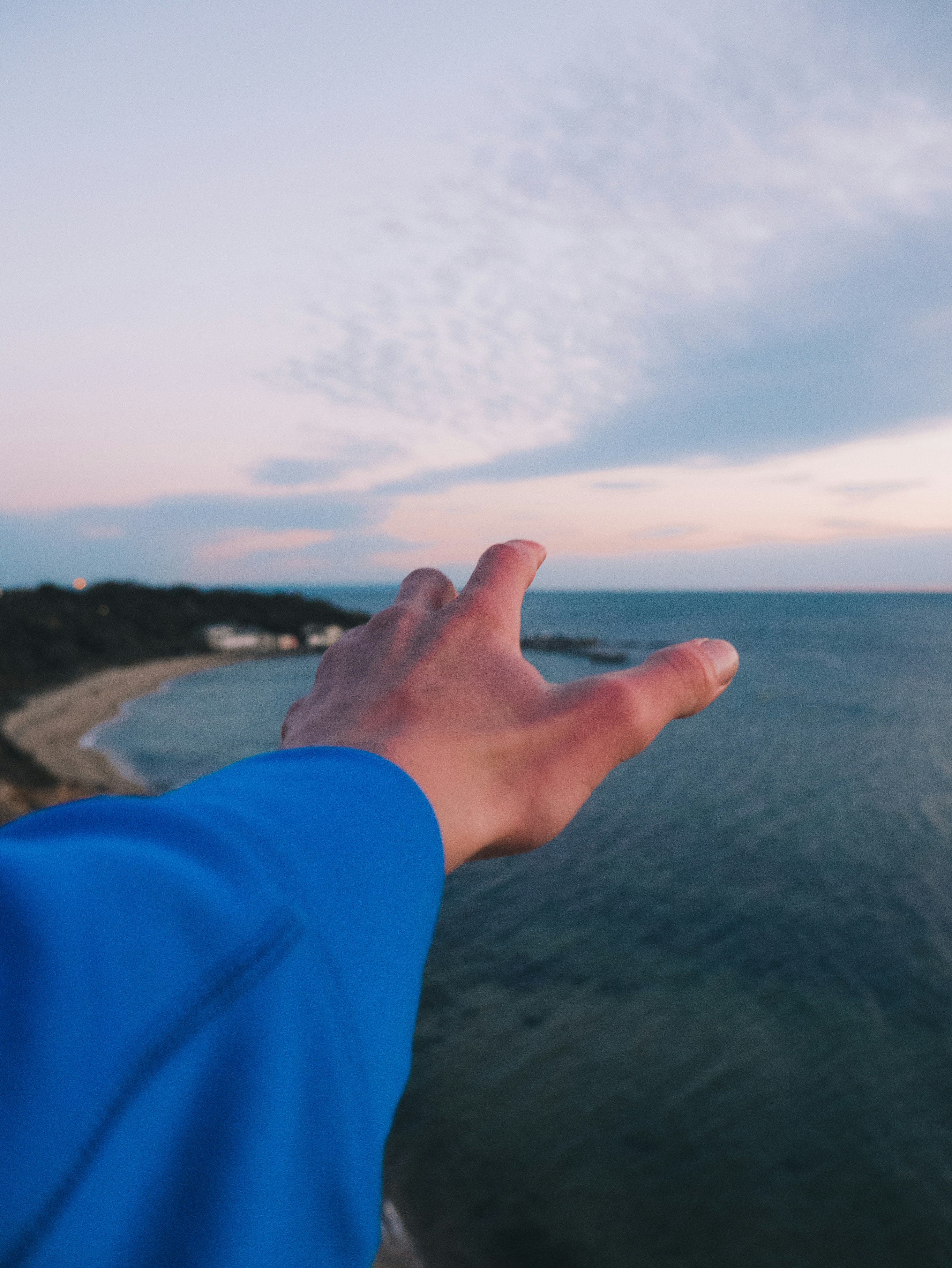 person in blue long sleeve shirt showing left hand