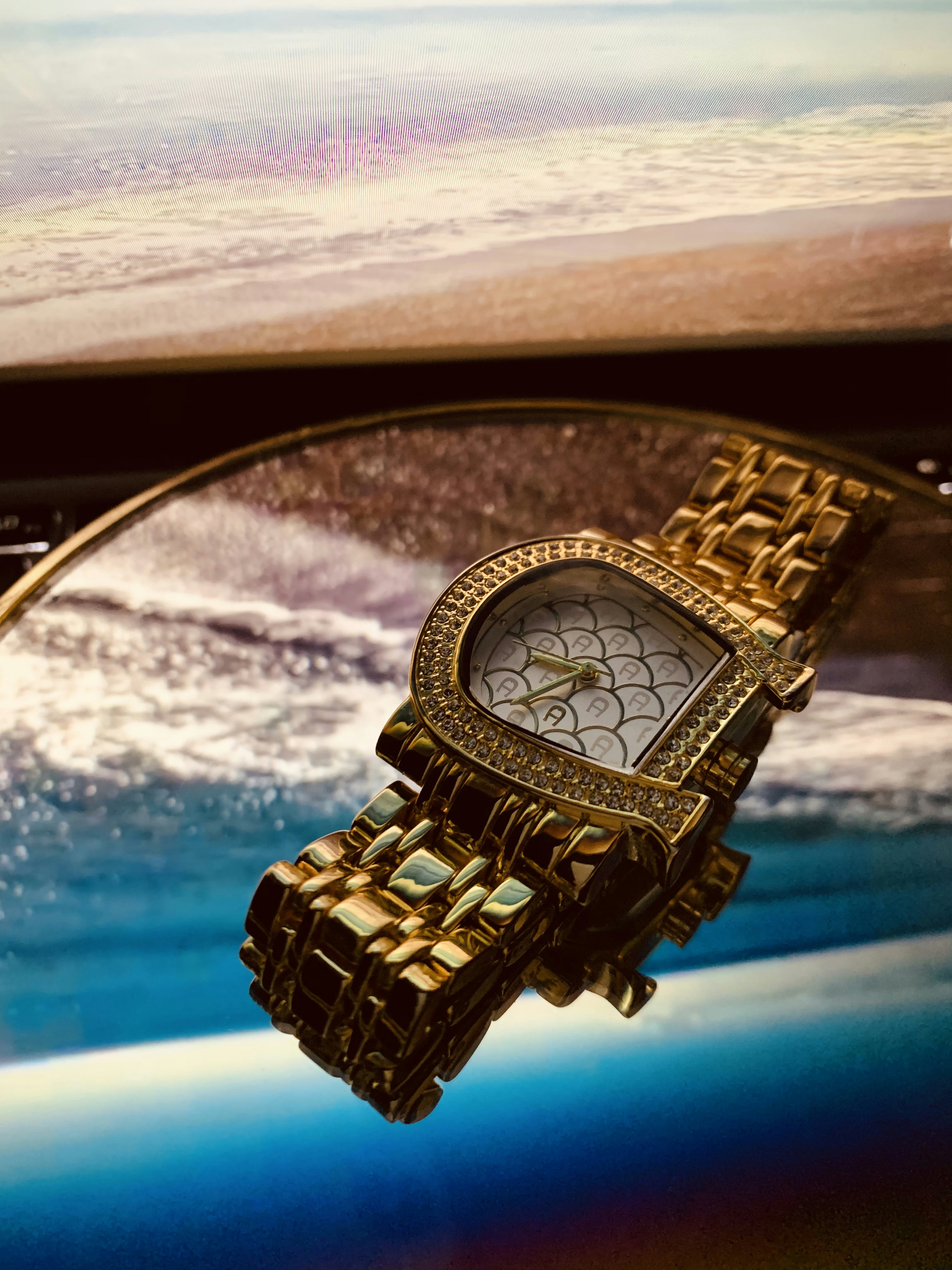 Reloj clásico dorado de lujo sobre superficie oscura con reflejo sutil y fondo negro