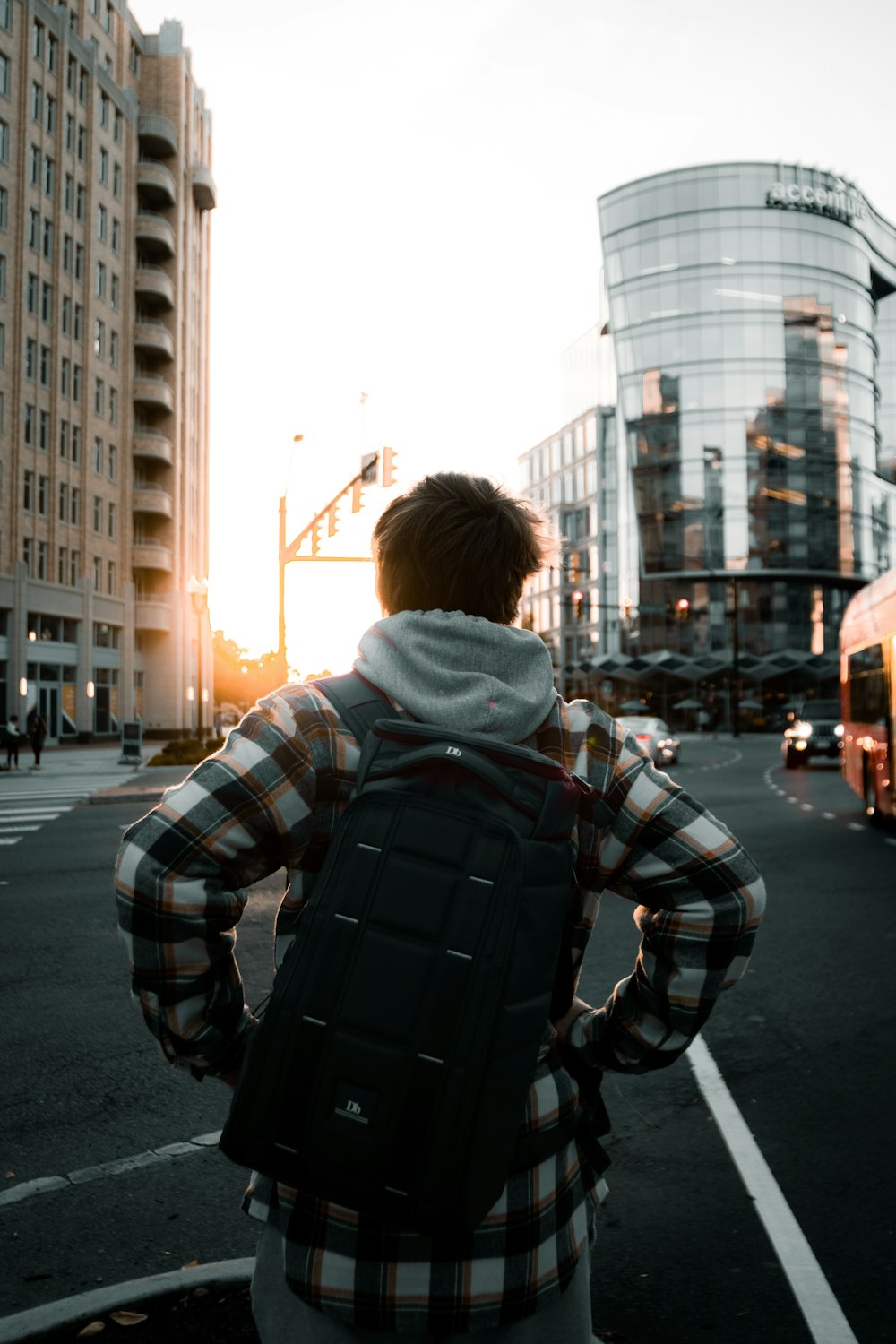 woman in blue and white striped hoodie standing on road during daytime