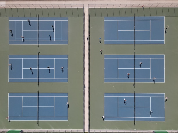 A tennis match being played on the bright courts at the school.