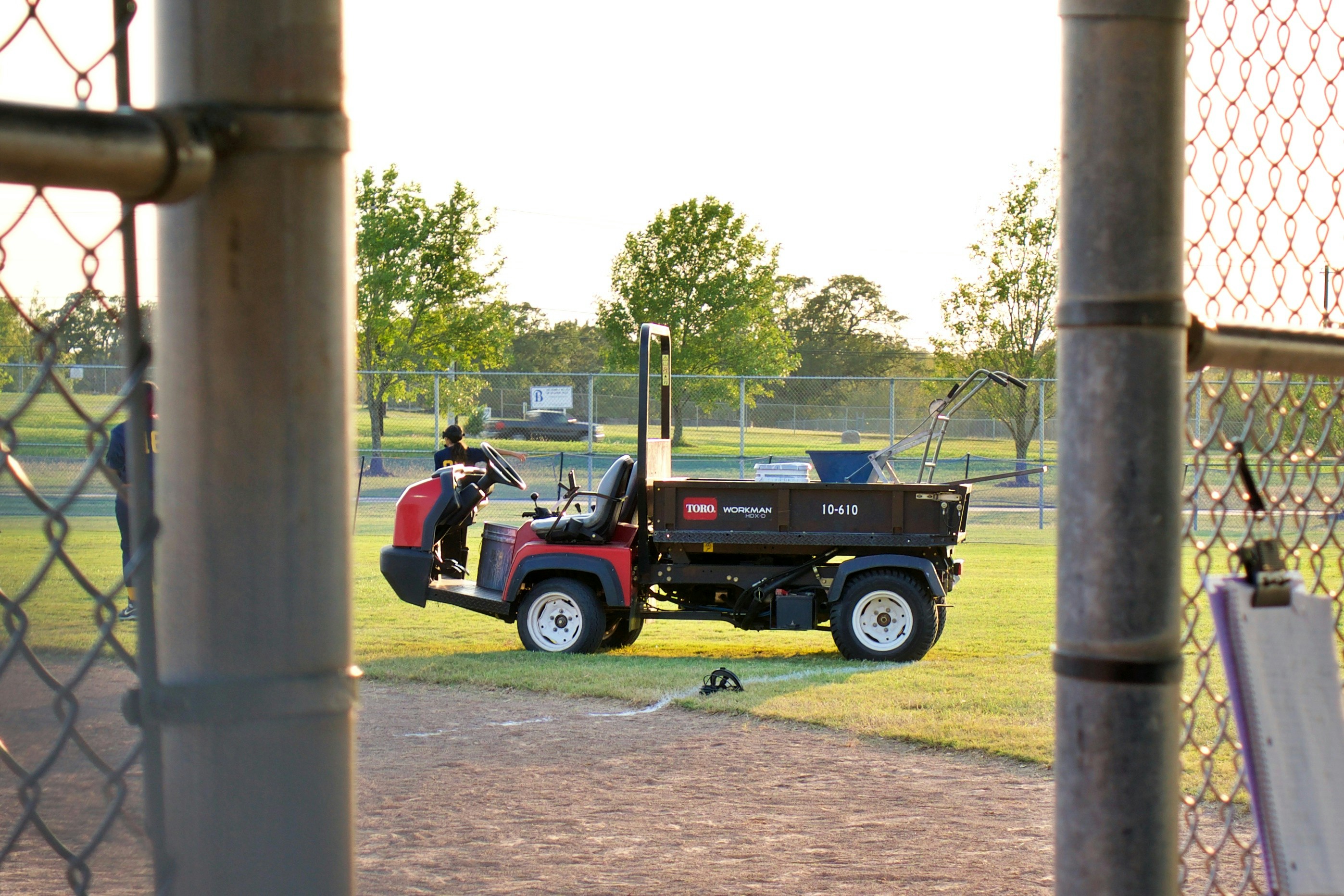 2 men riding red and black atv