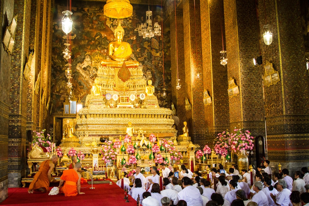 people in white shirt standing near gold temple during daytime