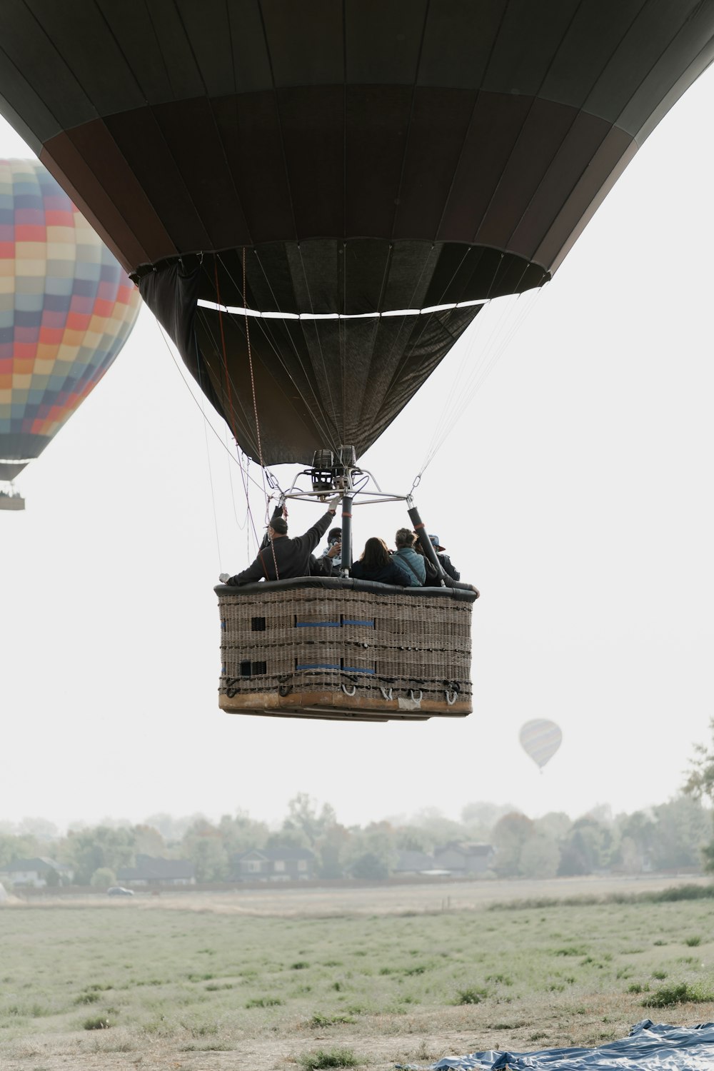 people sitting on brown wicker basket under hot air balloon during daytime