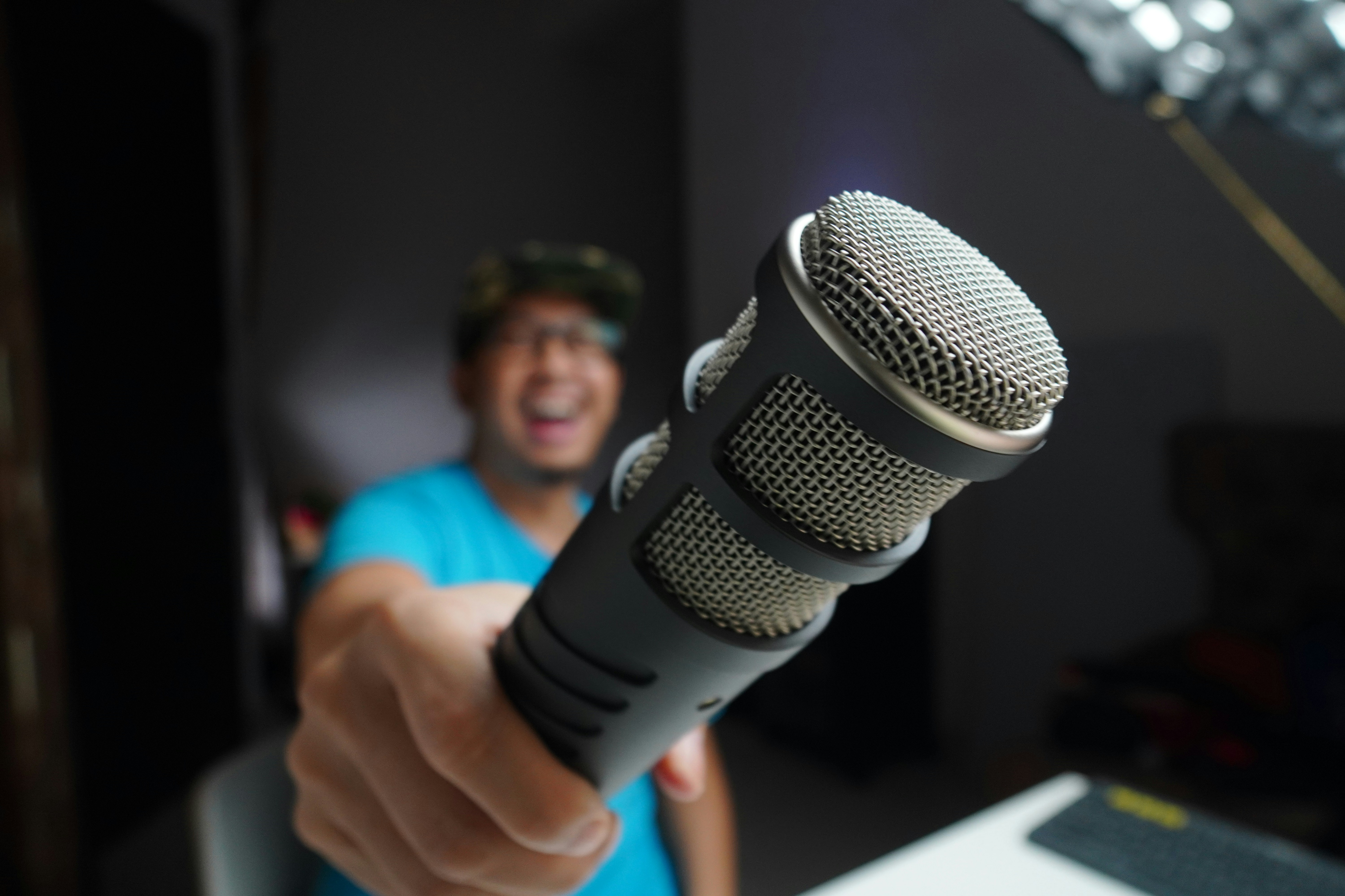 A man holds a microphone up to the camera as he records the best royalty free sound effects for vlogs.