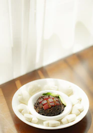 A beautifully plated Chinese fusion dish with vintage-style table setting