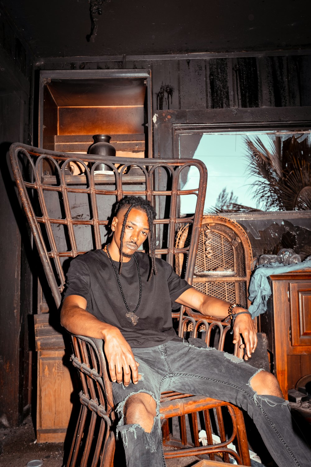 man in black jacket sitting on brown wooden armchair