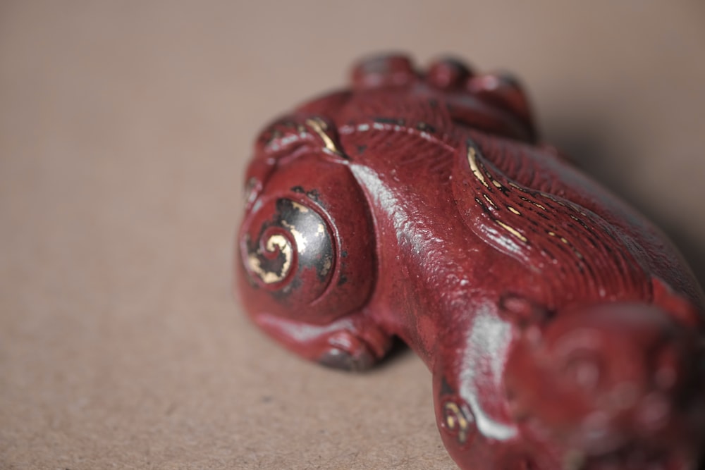 red plastic toy on brown surface