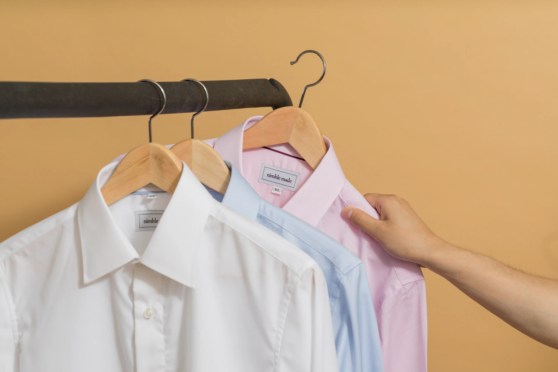 A navy blue slim fit formal shirt hanging on a wooden hanger, showcasing its polished look and perfect fit for a professional wardrobe.