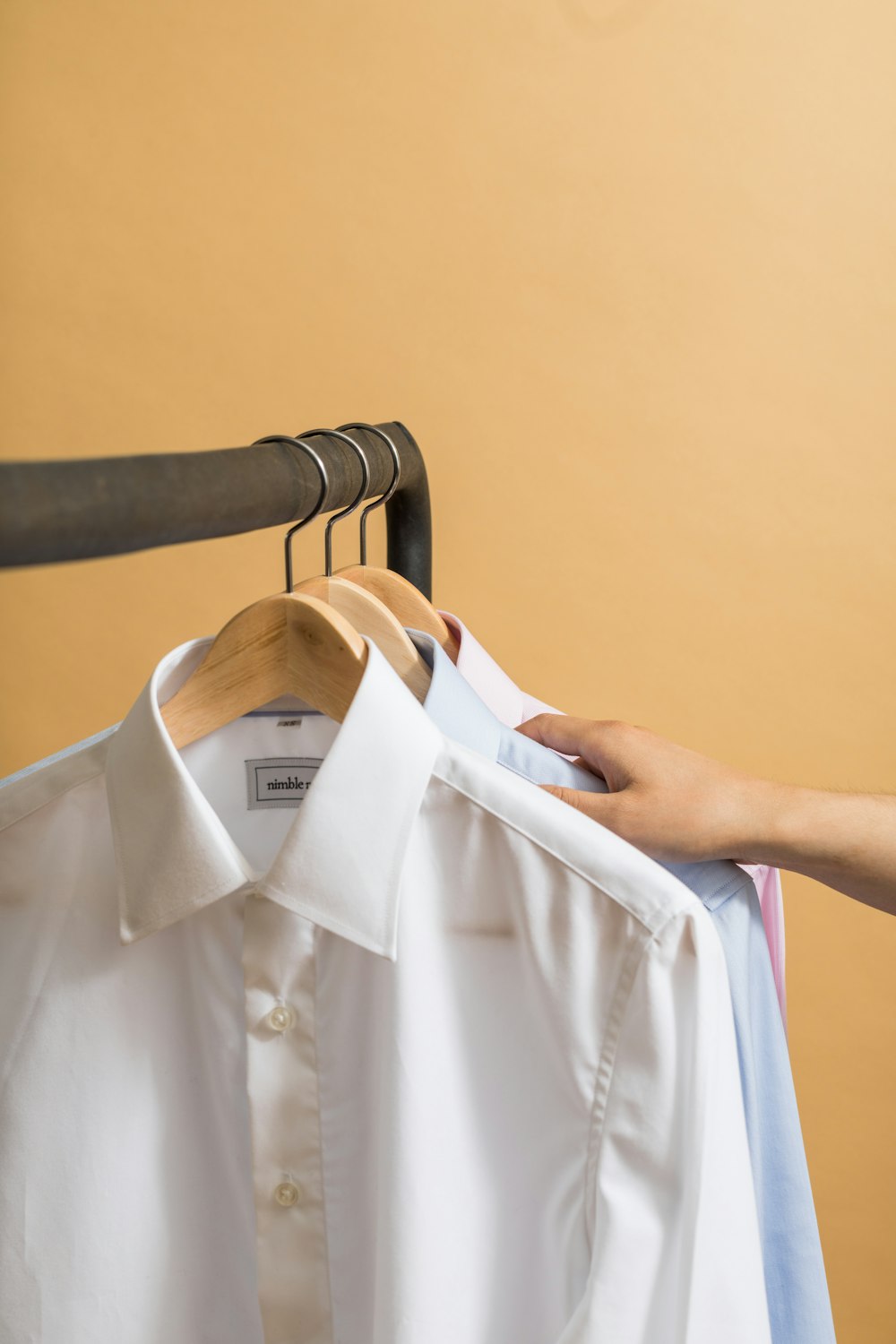 camisa branca do botão para cima no cabide da roupa