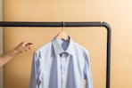 white button up shirt hanging on black metal bar