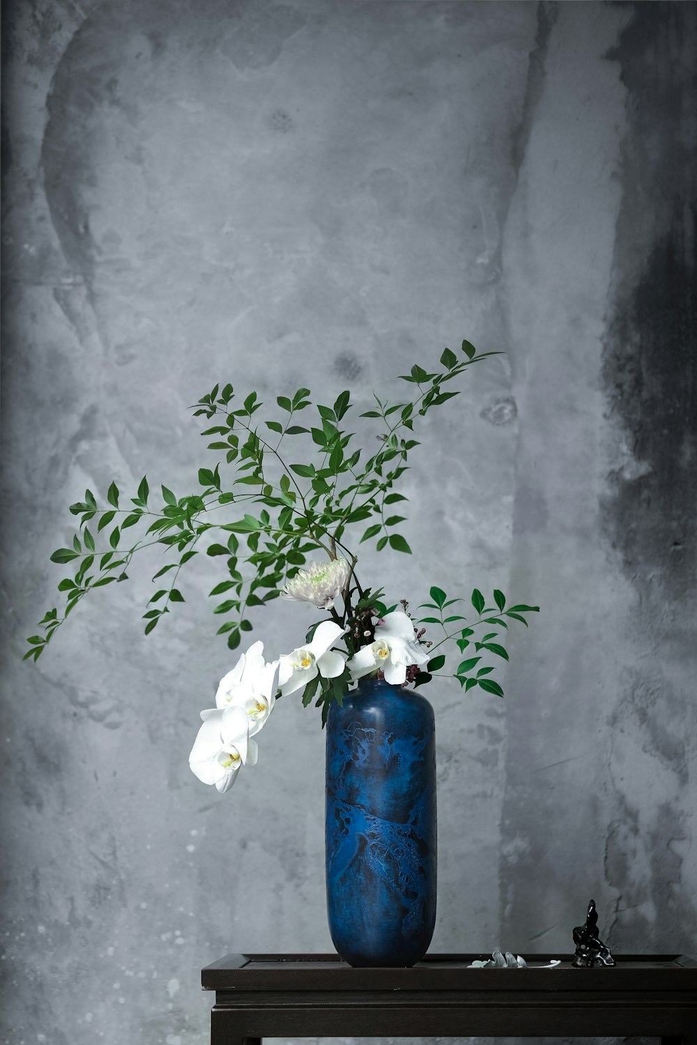 white flowers in blue vase