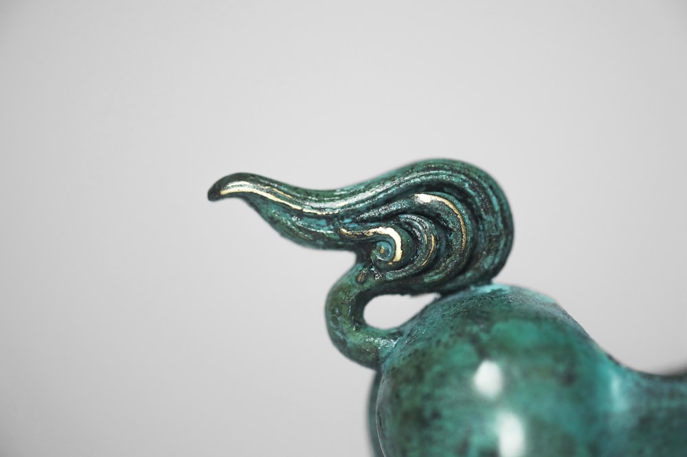 estatueta cerâmica verde e prateada do dragão