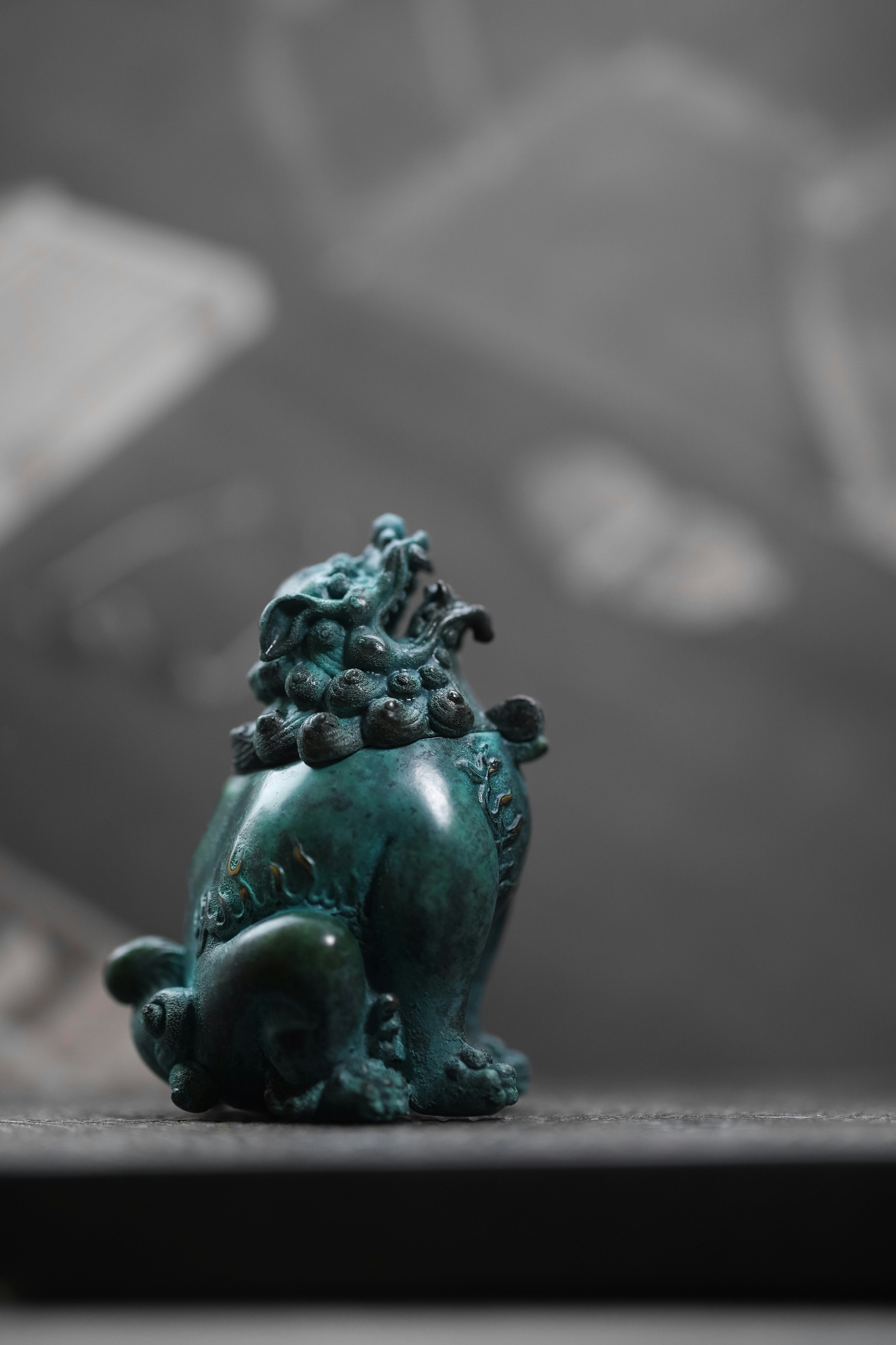 green ceramic dragon figurine on brown wooden table