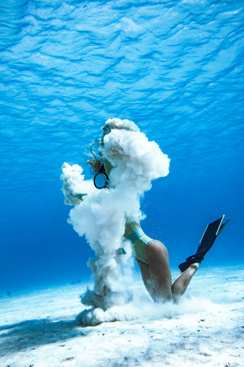 woman in black and blue bikini set holding white smoke