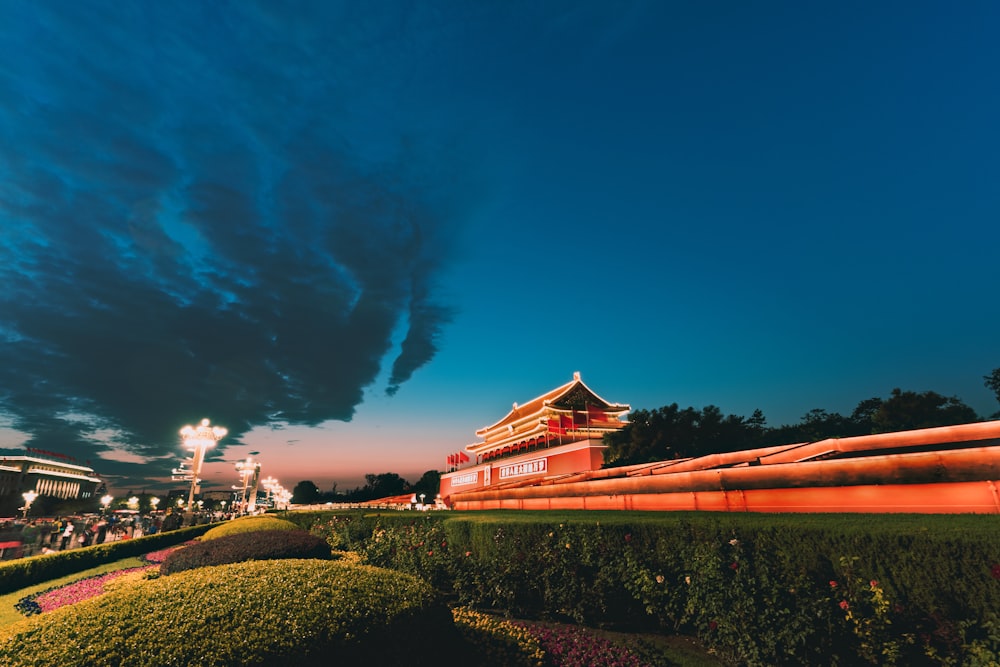 red and white house near green grass field under blue sky during nighttime