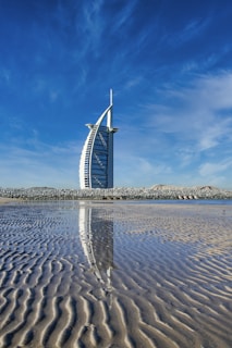 white and blue windmill on brown sand under blue sky during daytime