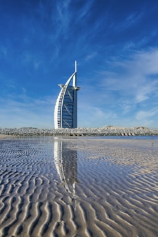 white and blue windmill on brown sand under blue sky during daytime