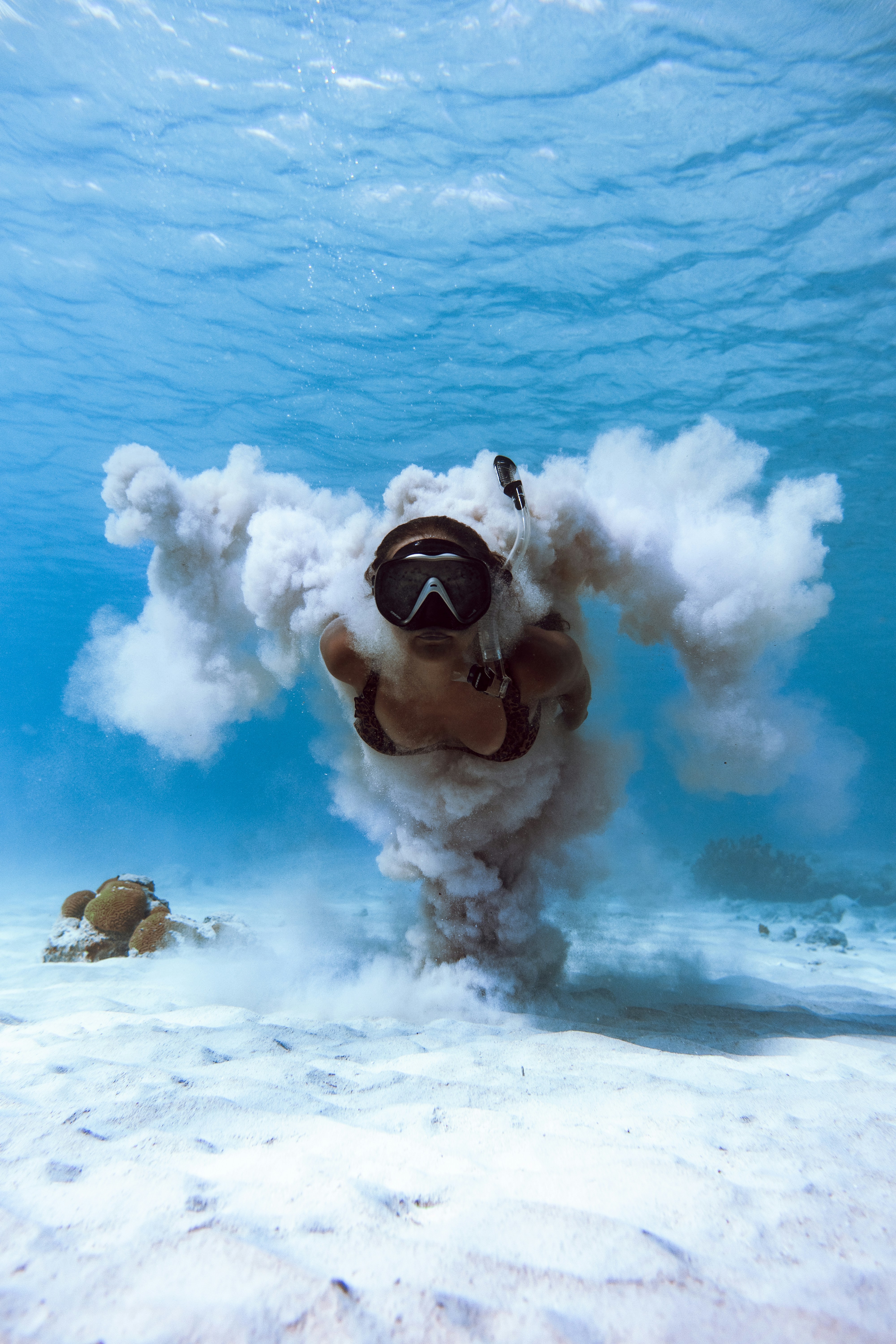 a woman doing freediving on a sandy bottom