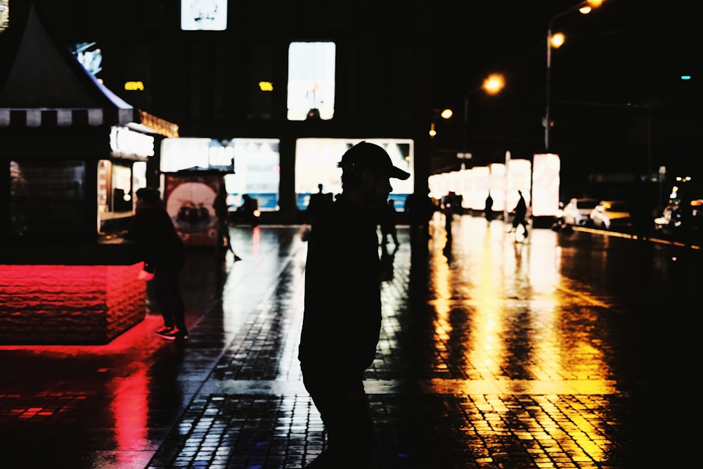 people walking on sidewalk during night time