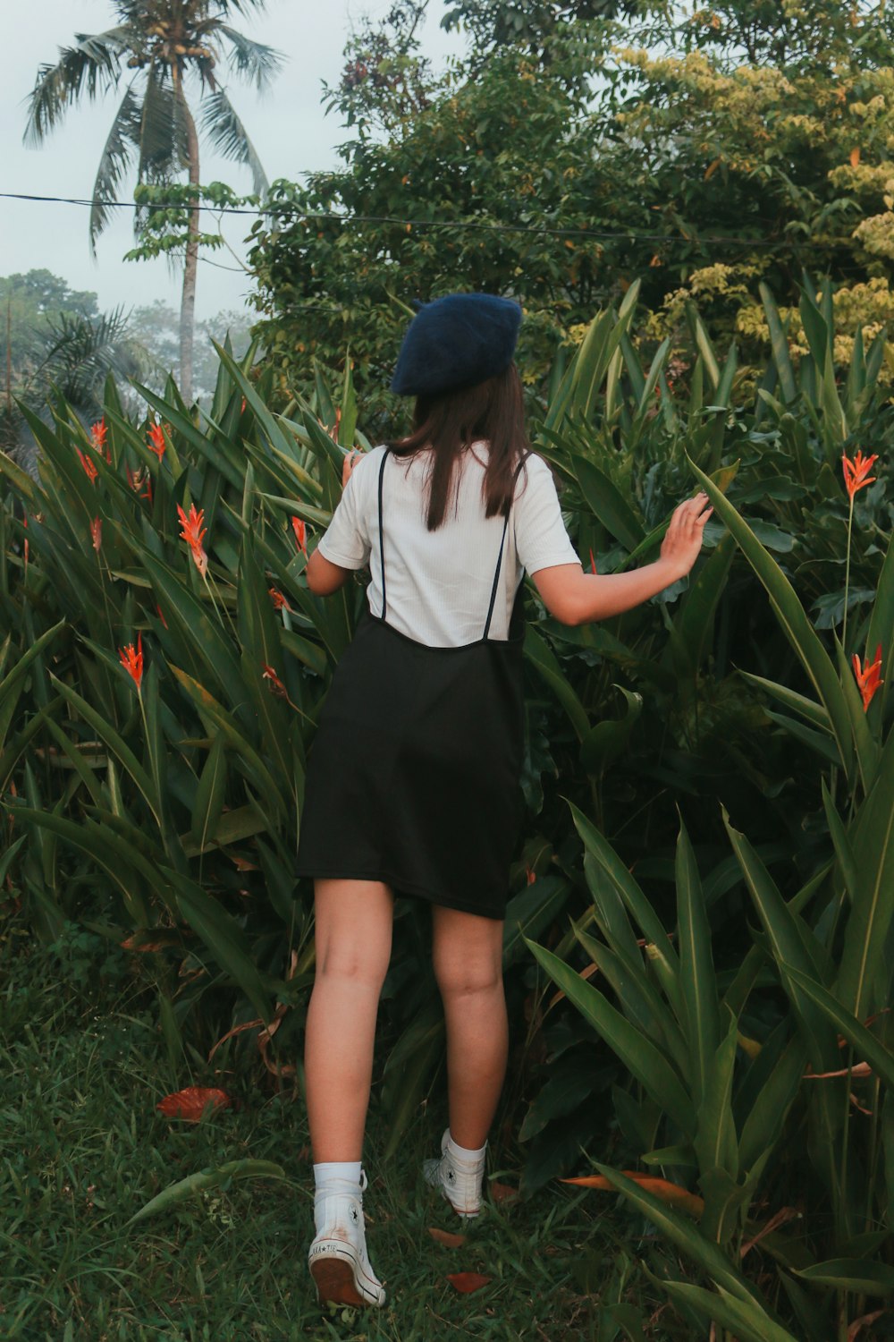 woman in white long sleeve shirt and black skirt standing on green grass field during daytime