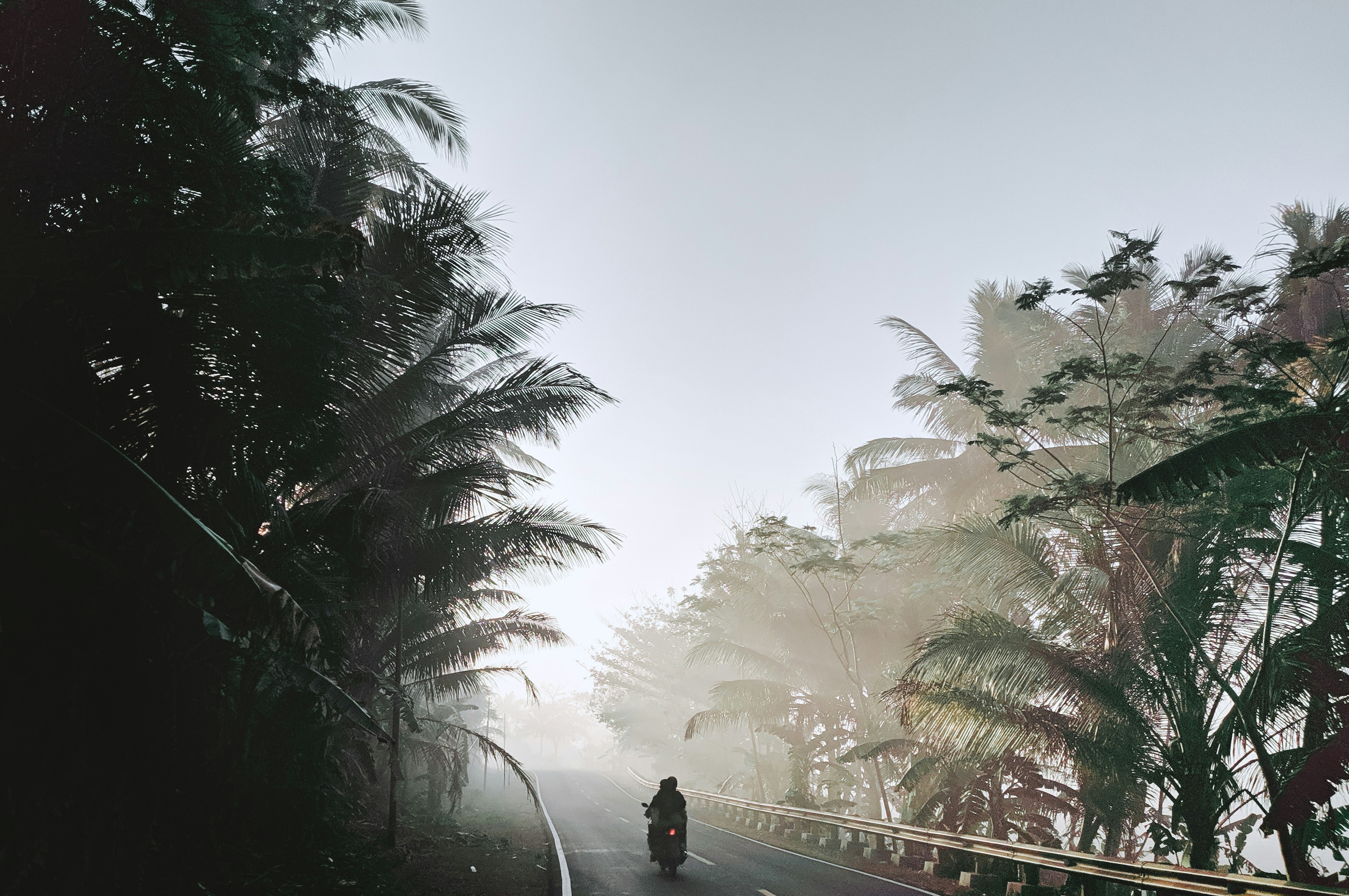 man in black jacket standing on bridge during daytime