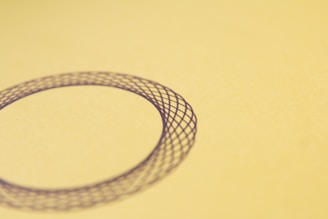 Minimalist medallion with intricate engraving, displayed against a clean, dark neutral background.