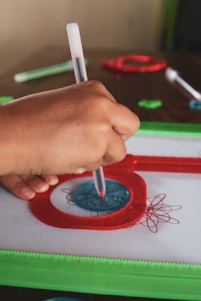 Close-up of a pen plotter meticulously drawing a vintage airplane blueprint on textured paper.