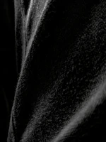 A pair of classic black denim jeans laid out flat with subtle lighting highlighting the texture.
