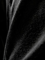 Close-up of hands showcasing the texture and quality of khld’s black fabric.