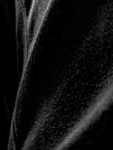 Artistic shot of black denim fabric texture highlighting premium quality and design.