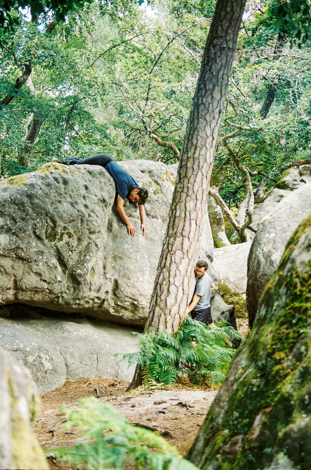 Frau im schwarzen T-Shirt klettert auf braunen Felsen