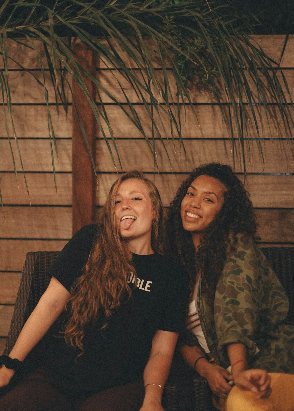 woman in black crew neck t-shirt beside woman in brown and black leopard print long