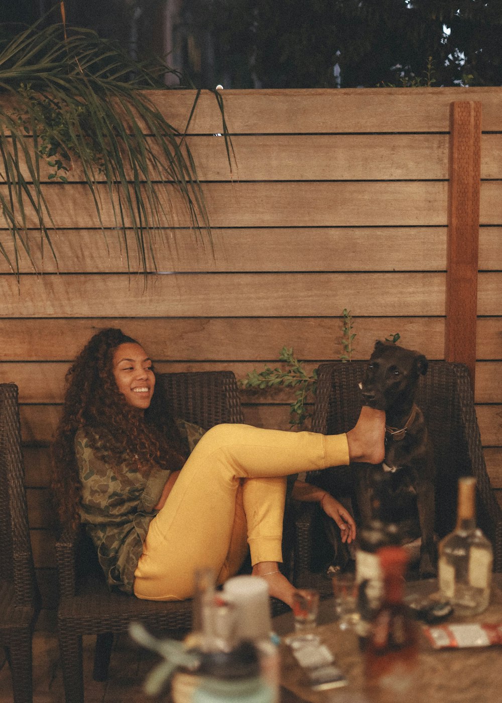 woman in brown long sleeve shirt sitting beside black and brown short coated dog