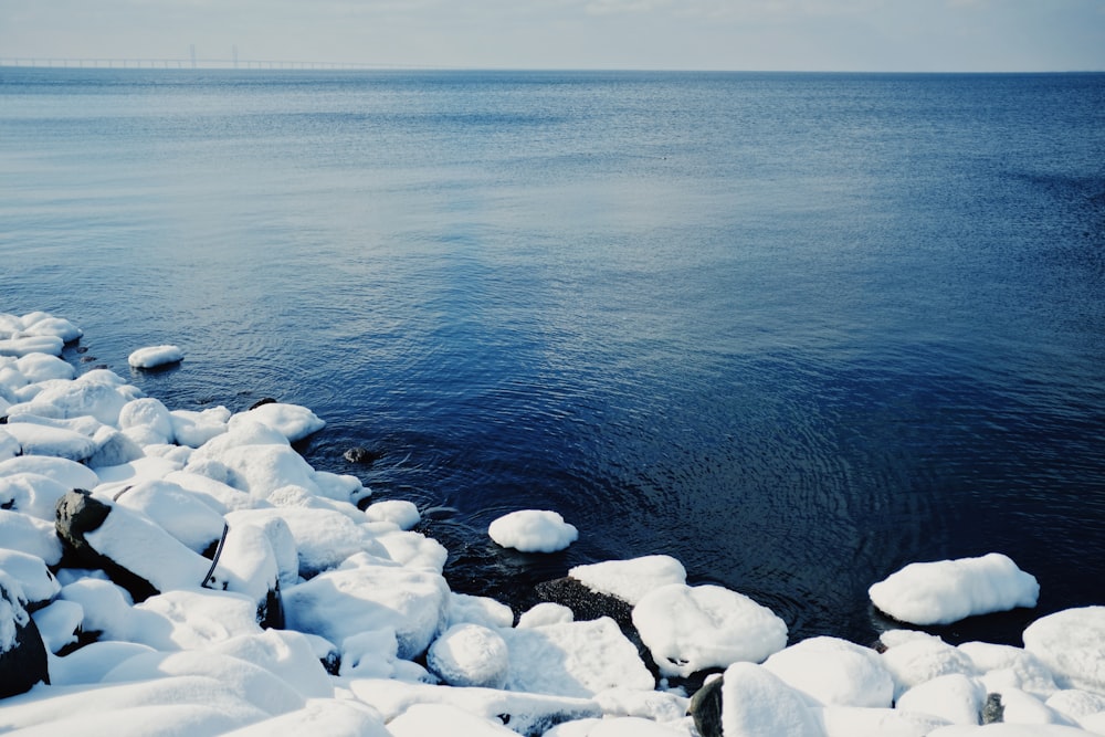 white and gray rocks beside body of water during daytime