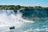 blue and white boat on water falls during daytime