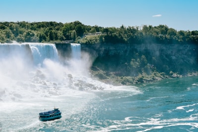 blue and white boat on water falls during daytime