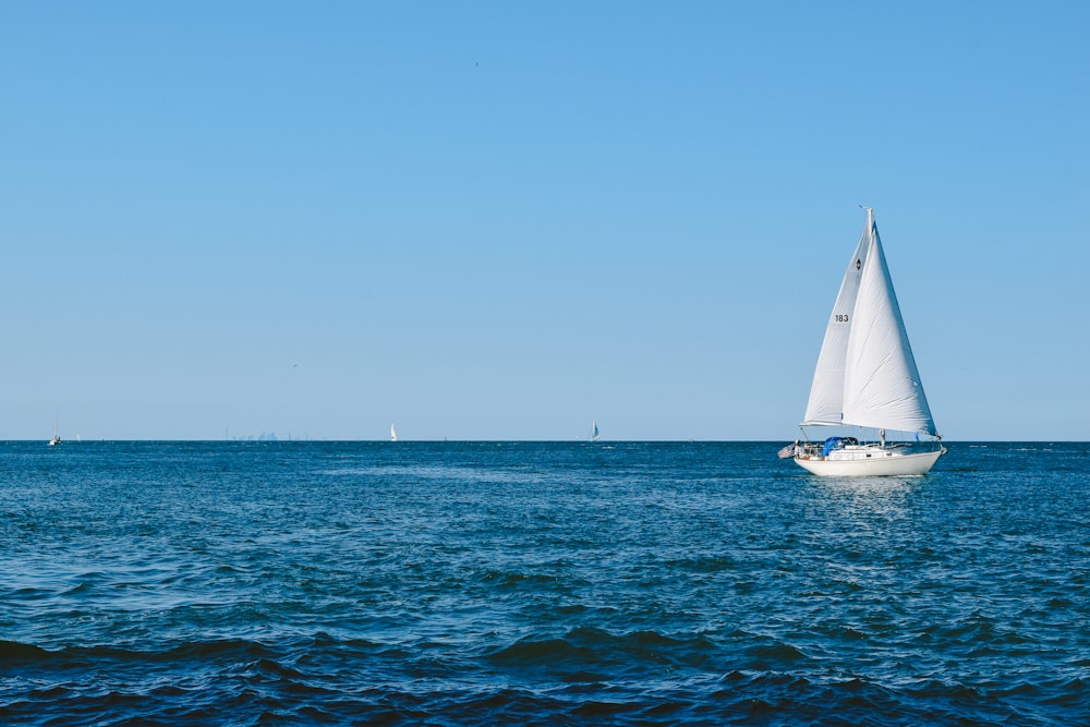 昼間の青空に浮かぶ白い帆船