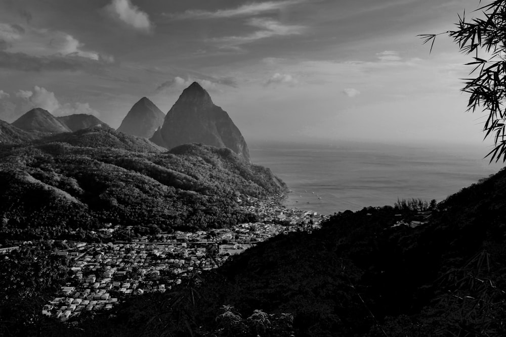 grayscale photo of mountain near body of water