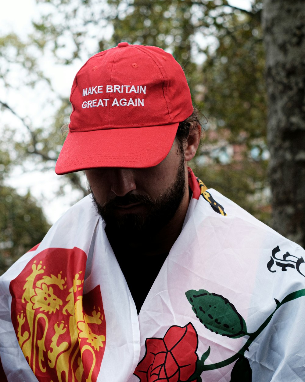 man in white and orange floral button up shirt wearing red cap