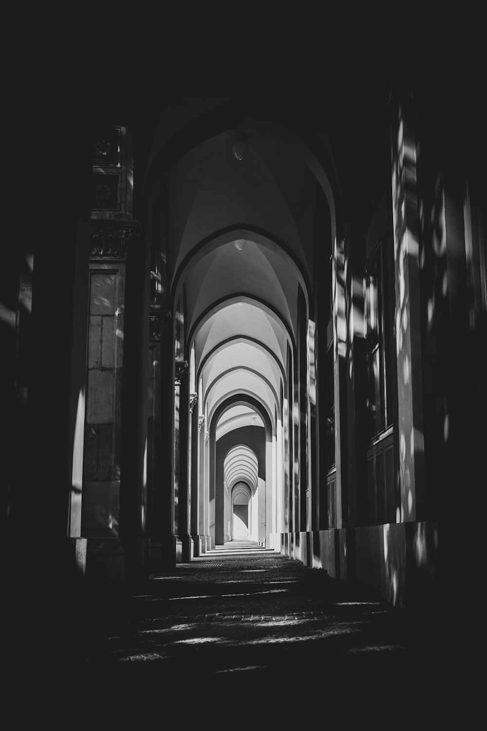 grayscale photo of hallway with columns