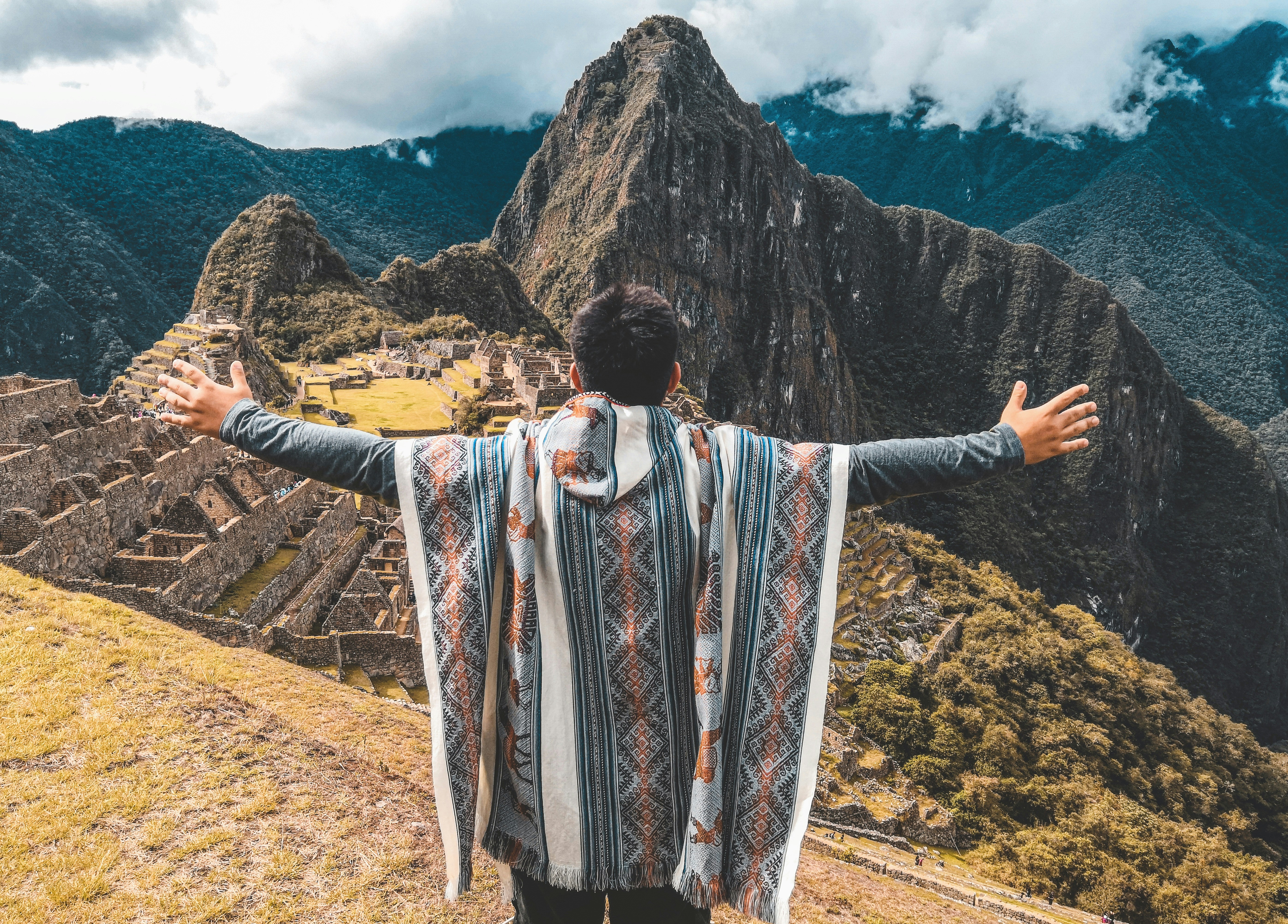 woman in white red and blue long sleeve dress standing on brown field during daytime