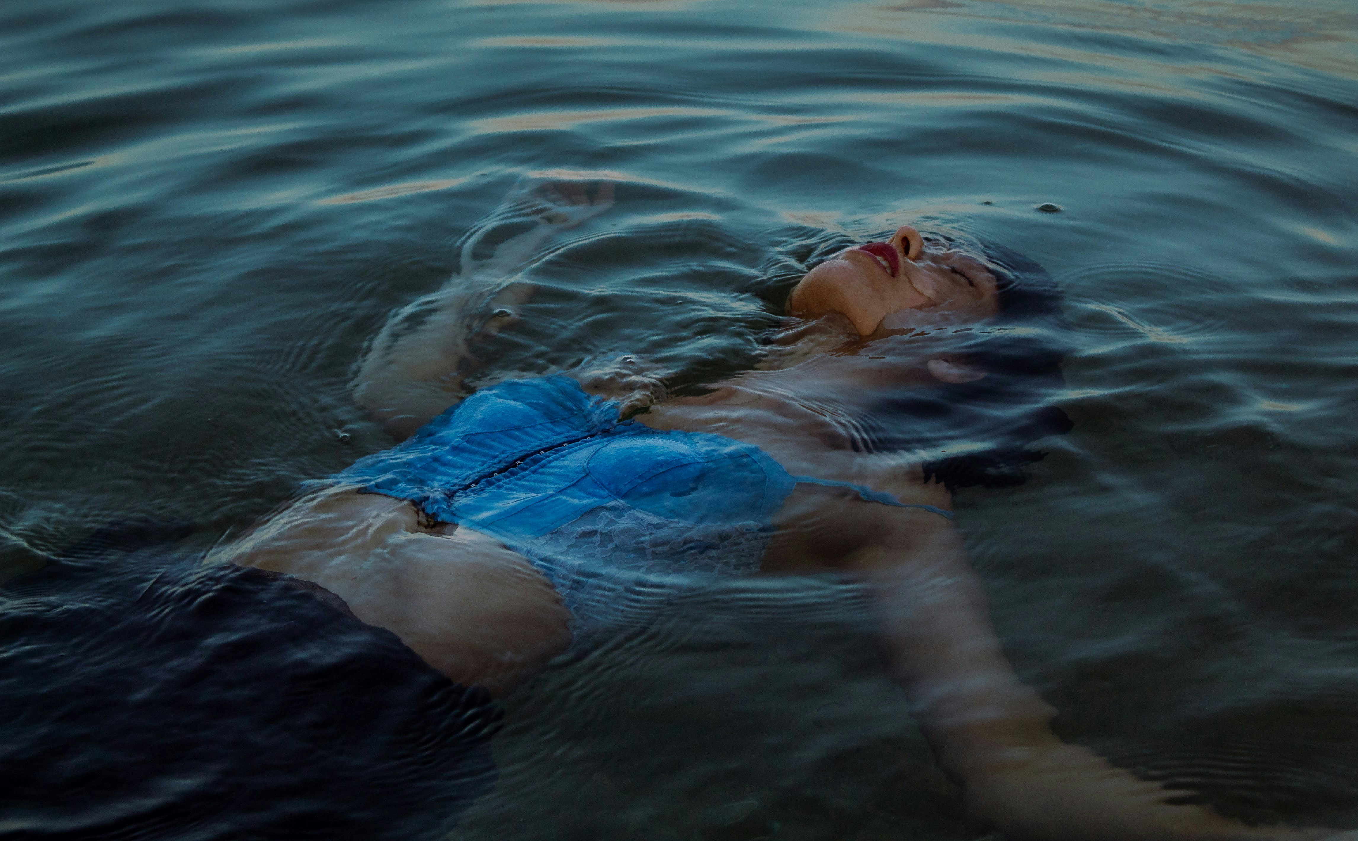 woman in blue bikini lying on water