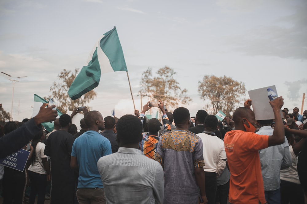 people gathering in a field with flags during daytime