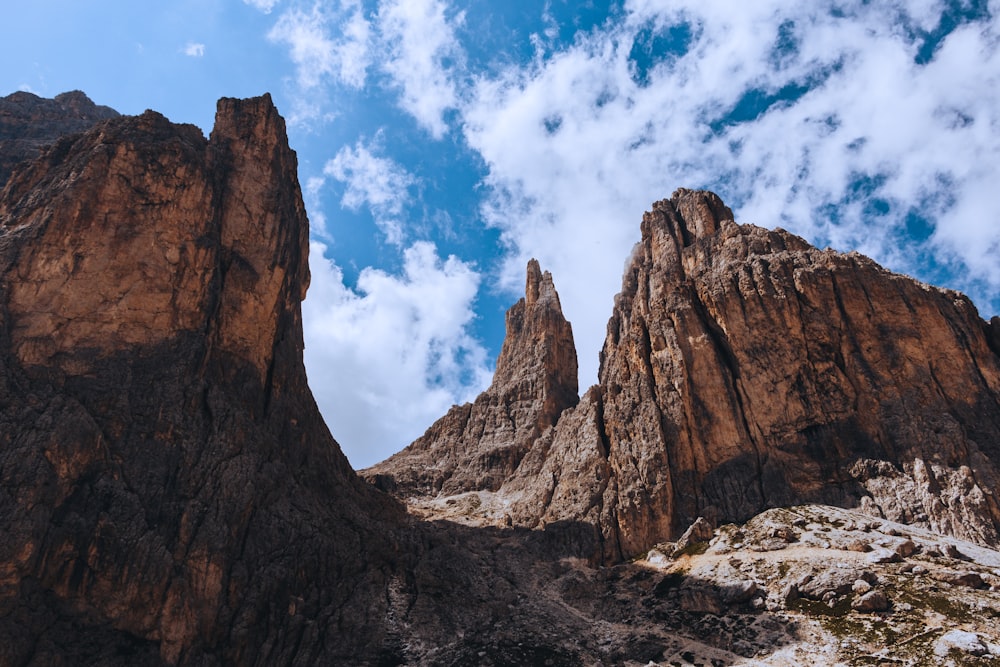 brown rocky mountain under blue sky and white clouds during daytime