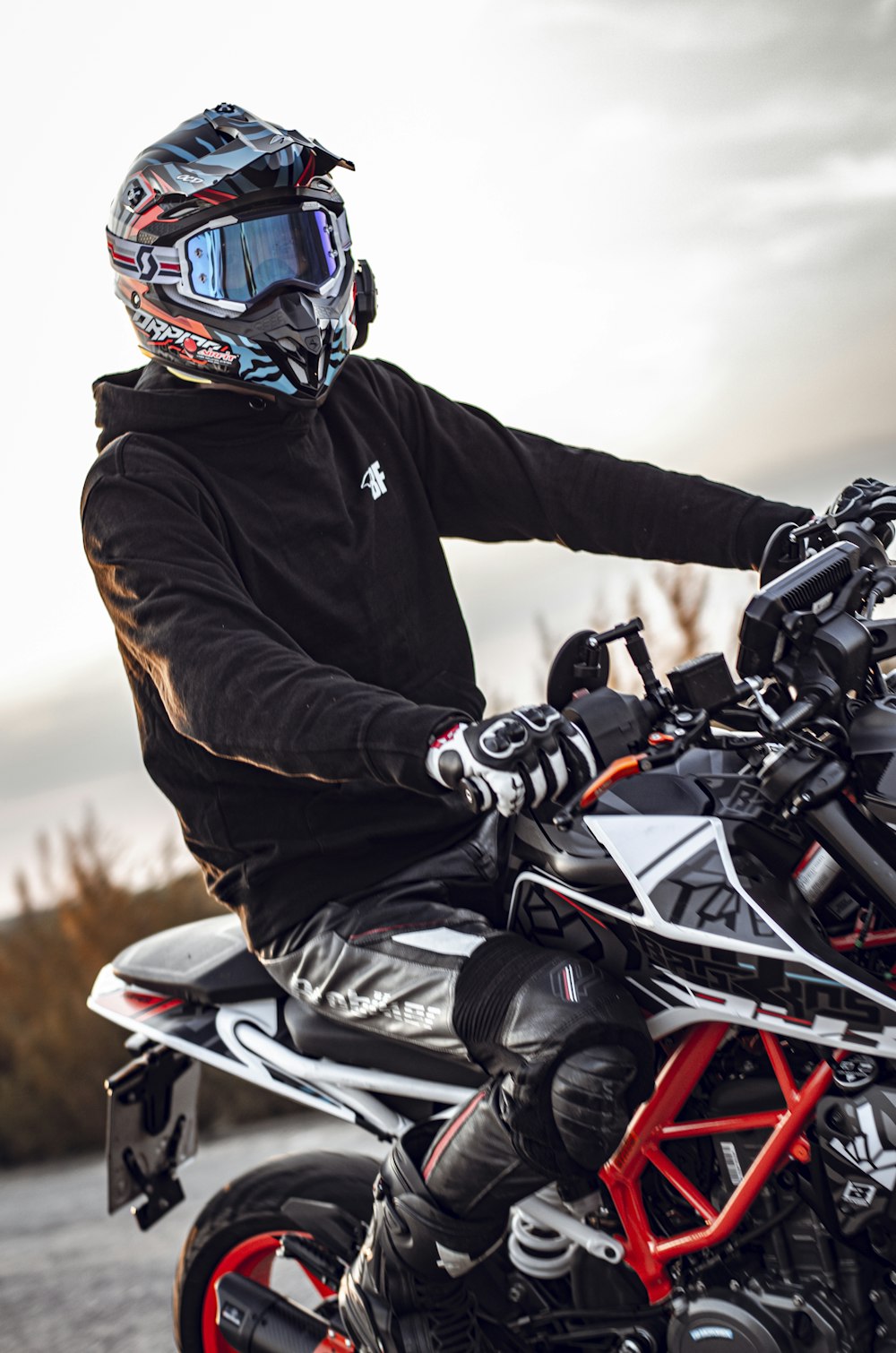 man in black jacket riding white and black sports bike