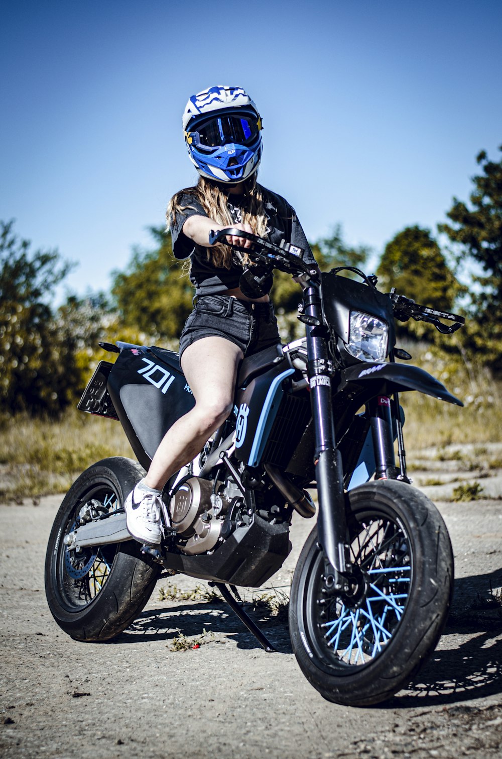 Hombre con casco azul montando motocicleta negra
